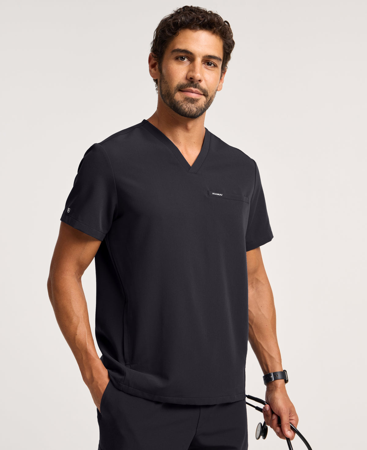 Jaanuu Platt 3-Pocket Scrub Top in Black, product photo 1 of 6