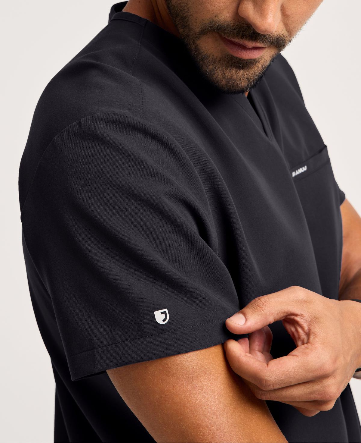Jaanuu Platt 3-Pocket Scrub Top in Black, product photo 3 of 6