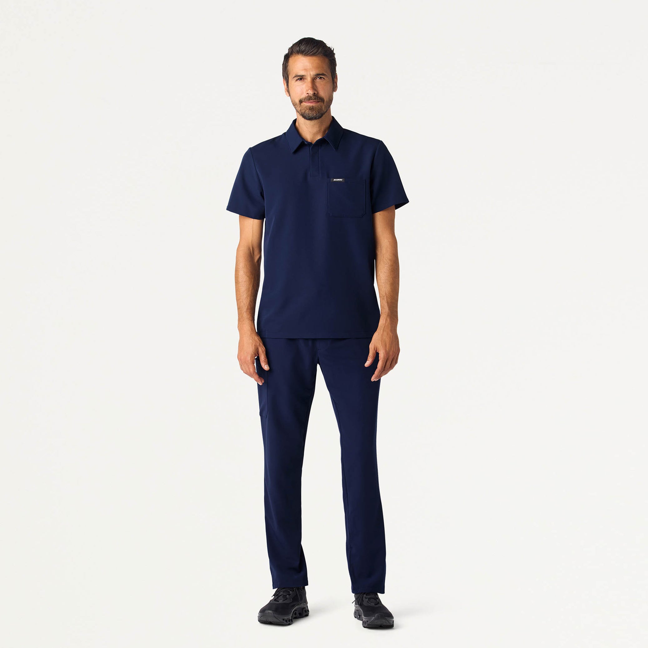 Man wearing a Midnight Navy scrub top and scrub pant