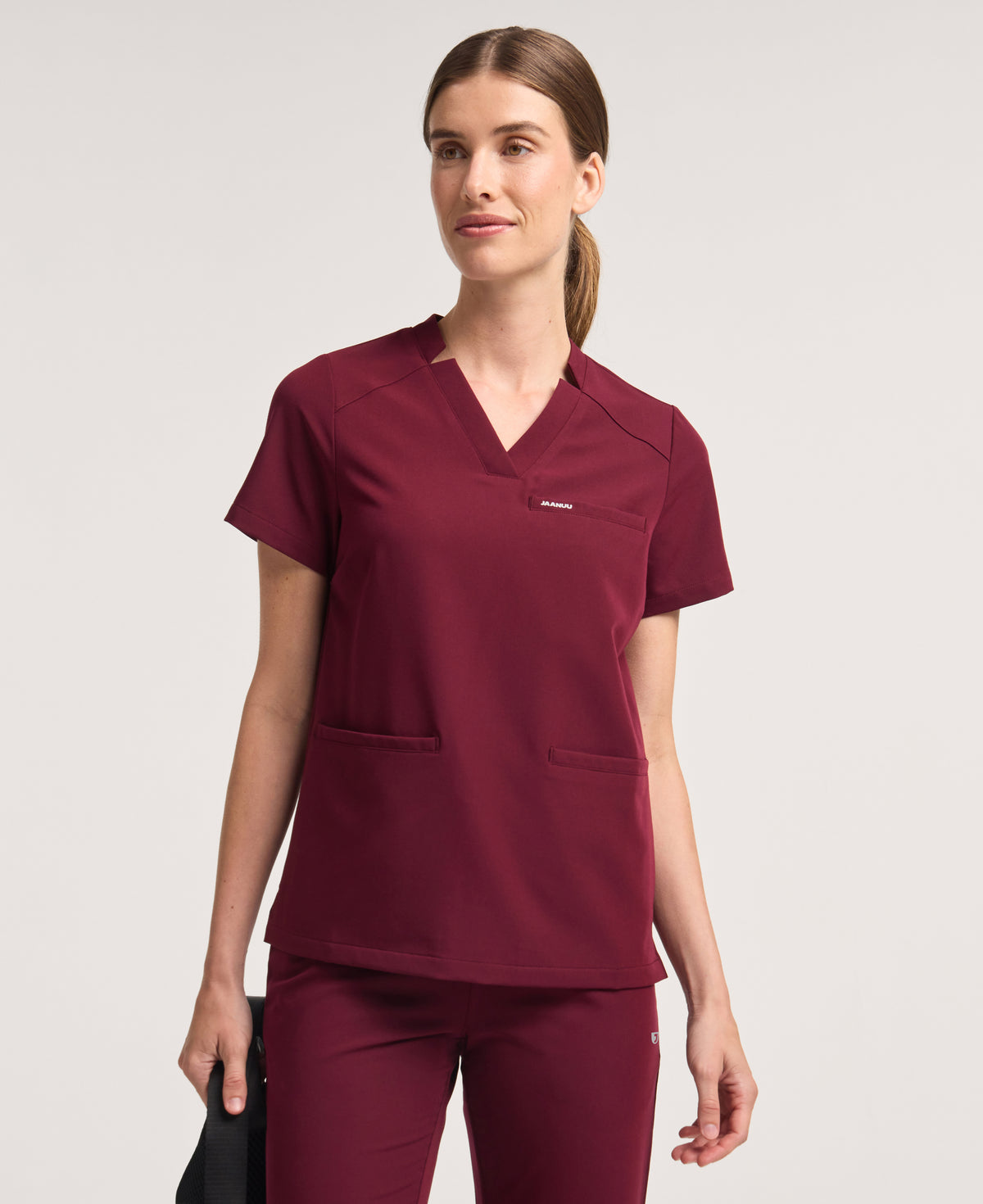 Jaanuu Helia Notched V-Neck Scrub Top in Burgundy, product photo 1 of 6