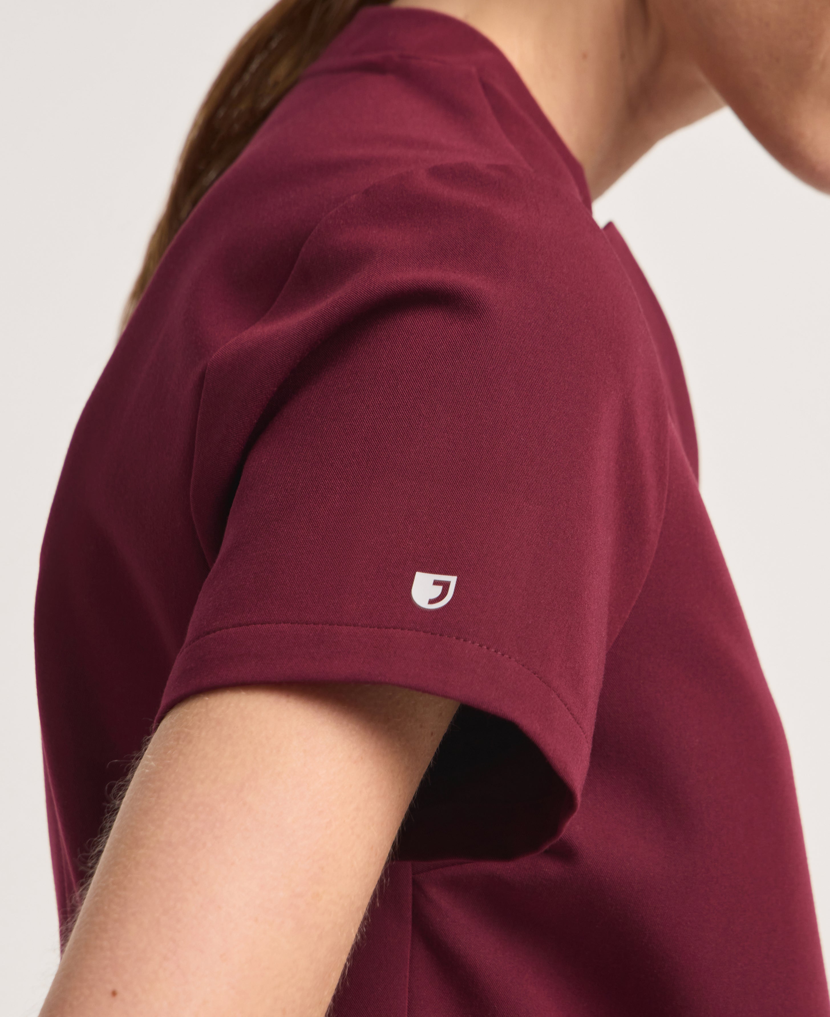 Jaanuu Helia Notched V-Neck Scrub Top in Burgundy, product photo 3 of 6