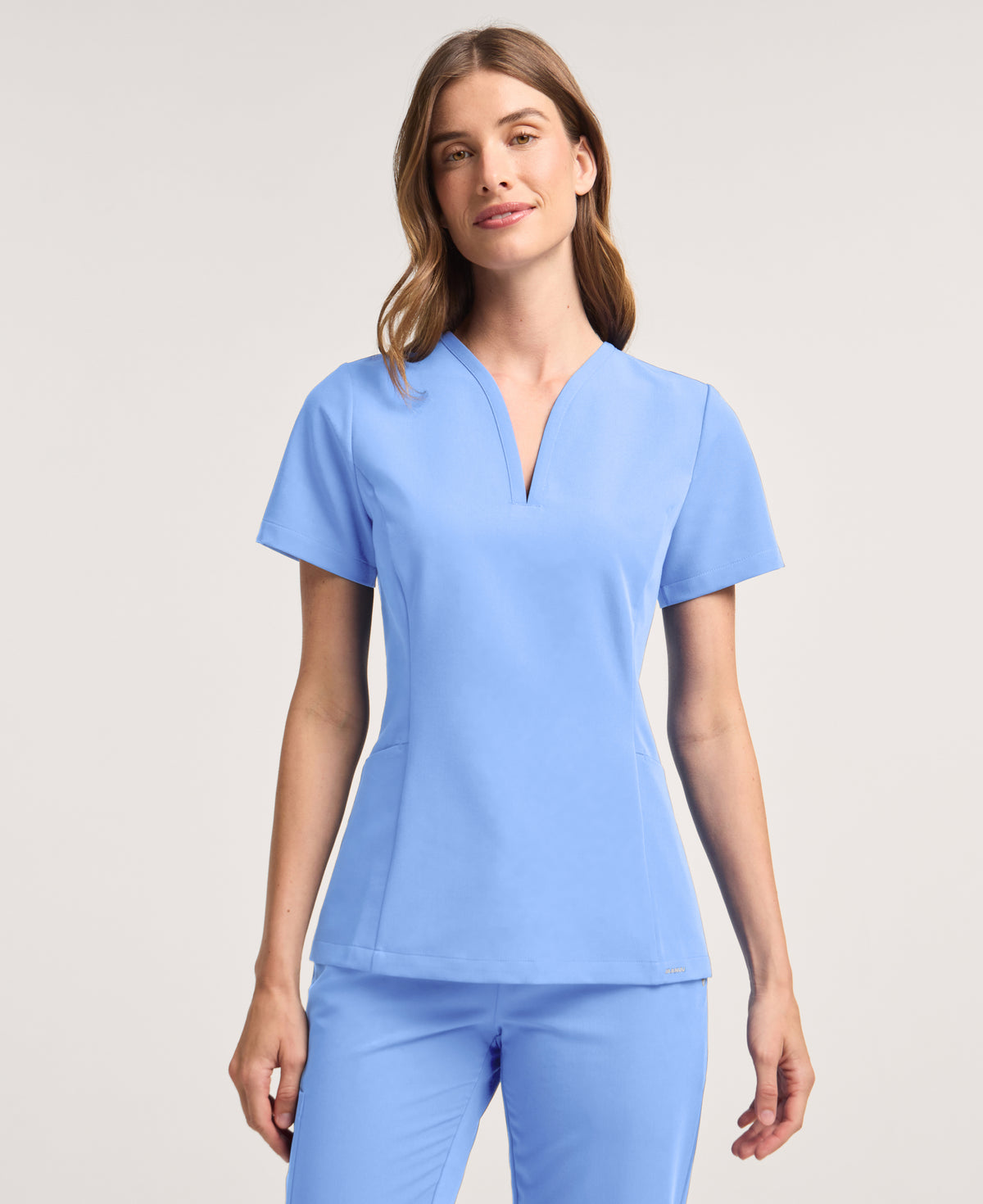 Jaanuu Calix Fit & Flare Scrub Top in Ceil Blue, product photo 1 of 6