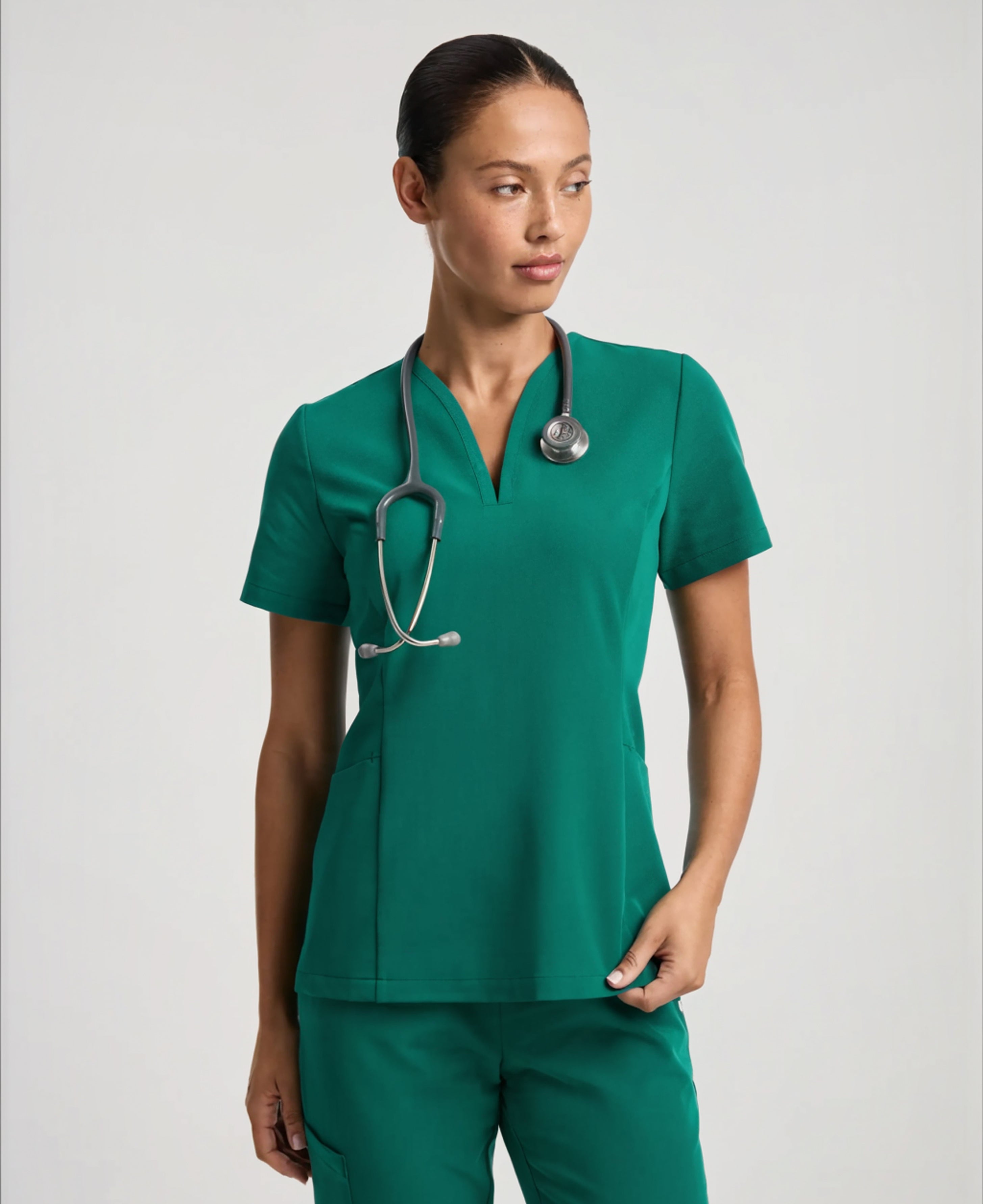 Jaanuu Calix Fit & Flare Scrub Top in Hunter Green, product photo 1 of 6