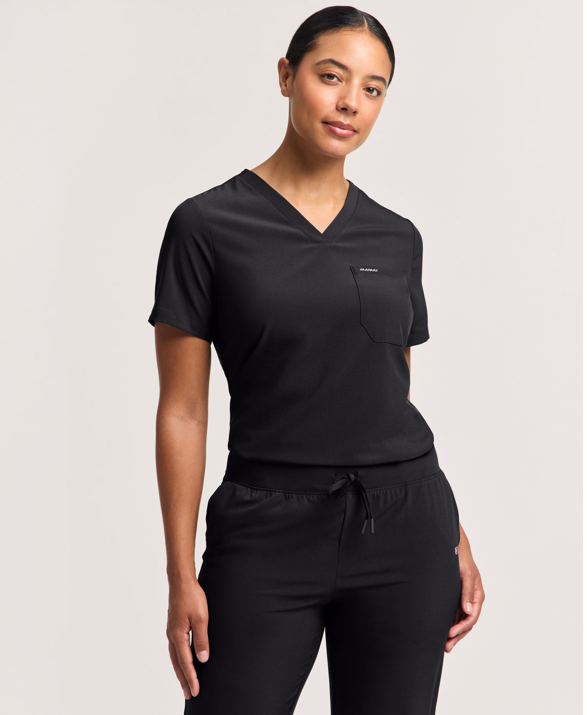 Jaanuu Harlow Slim 1-Pocket Scrub Top in Black, product photo 1 of 6