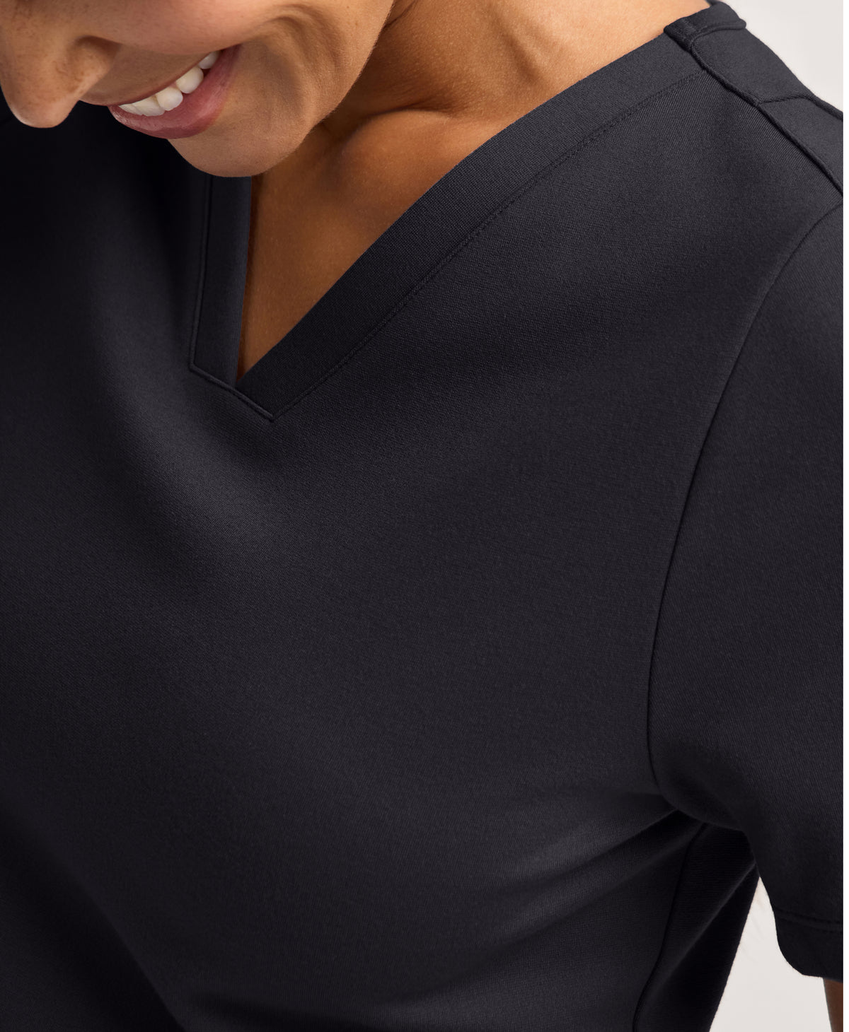 Jaanuu Kass Slim 4-Pocket Scrub Top in Black, product photo 1 of 6
