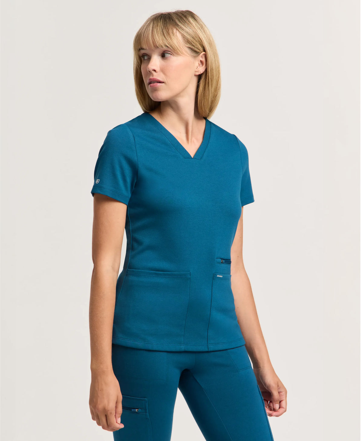 Jaanuu Kass Slim 4-Pocket Scrub Top in Caribbean Blue, product photo 1 of 6