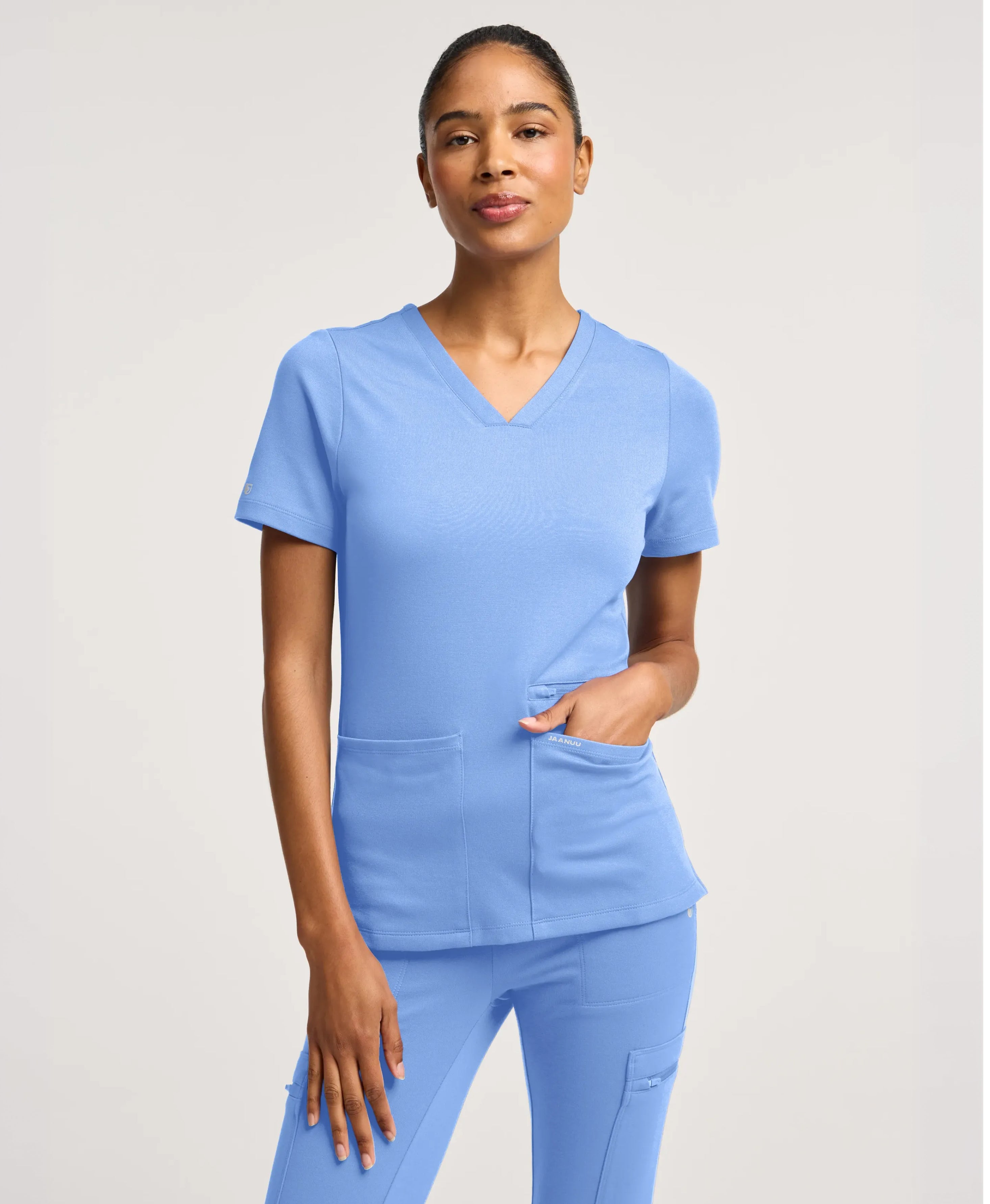 Jaanuu Kass Slim 4-Pocket Scrub Top in Ceil Blue, product photo 1 of 6