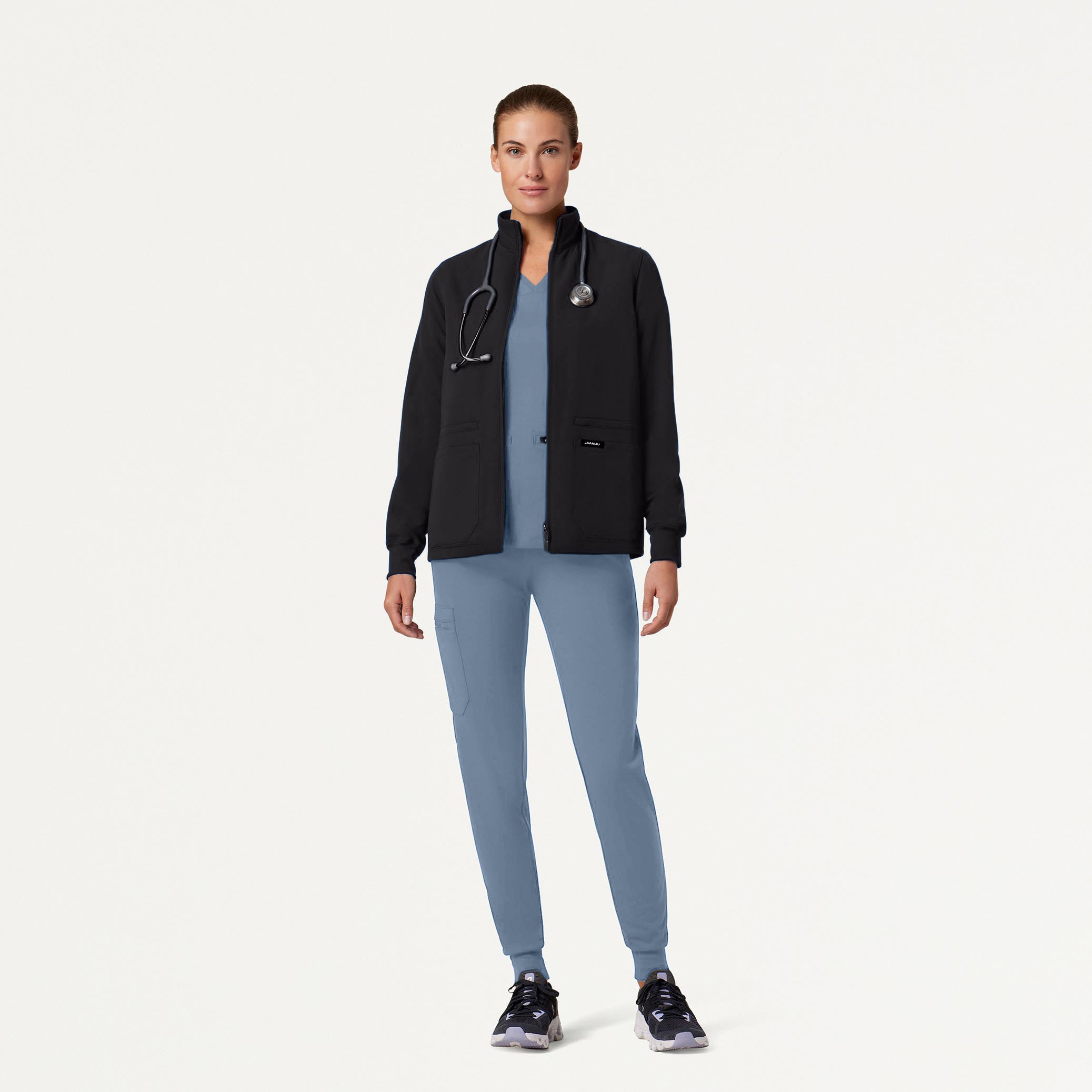 Woman wearing Storm Blue scrubs with jacket and stethoscope