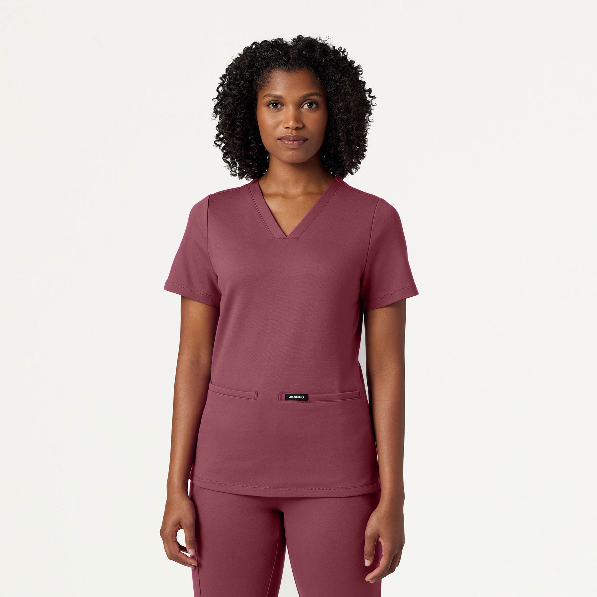 Woman wearing a Rosewood scrub set on a white background