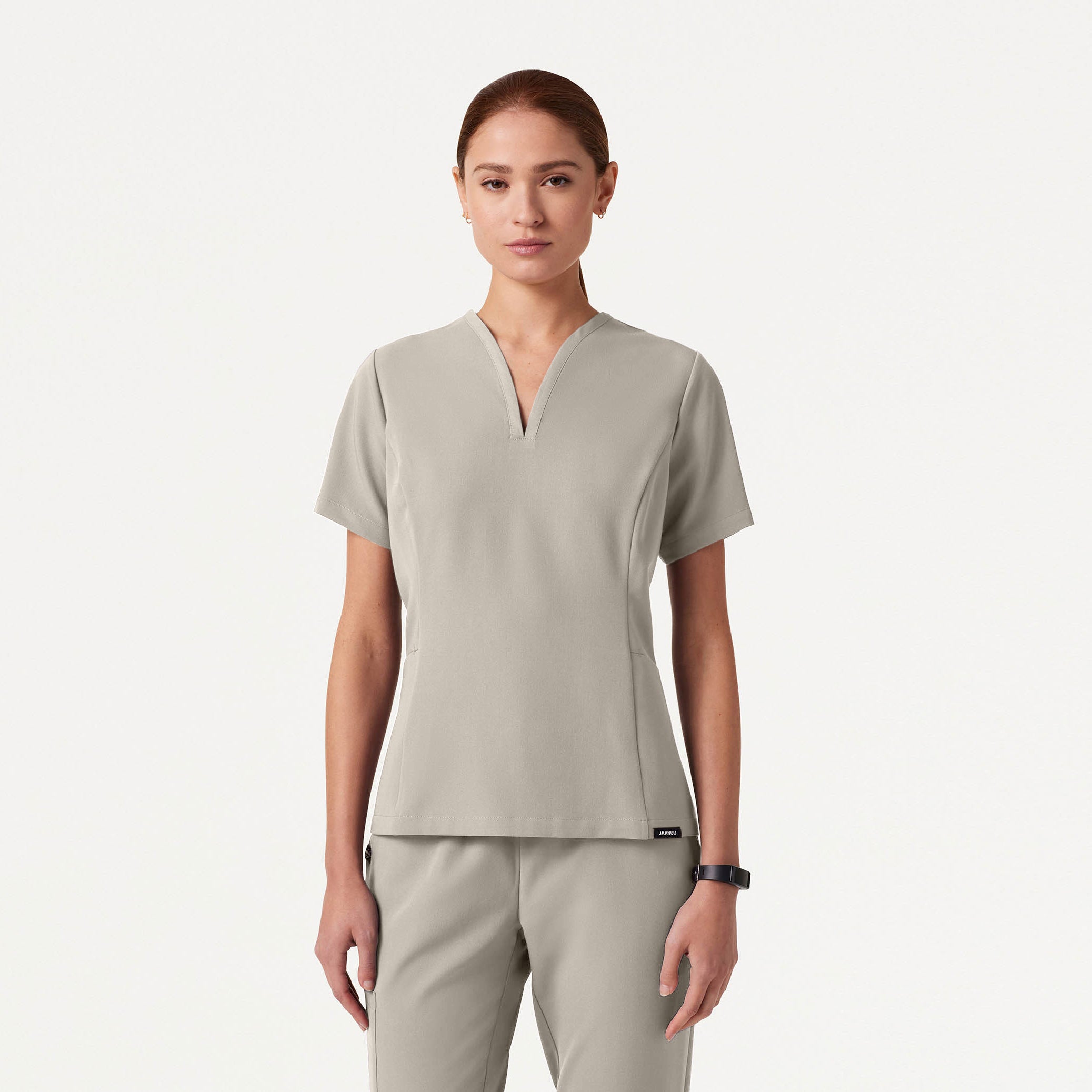 Woman wearing a Fog colored scrub set on a white background