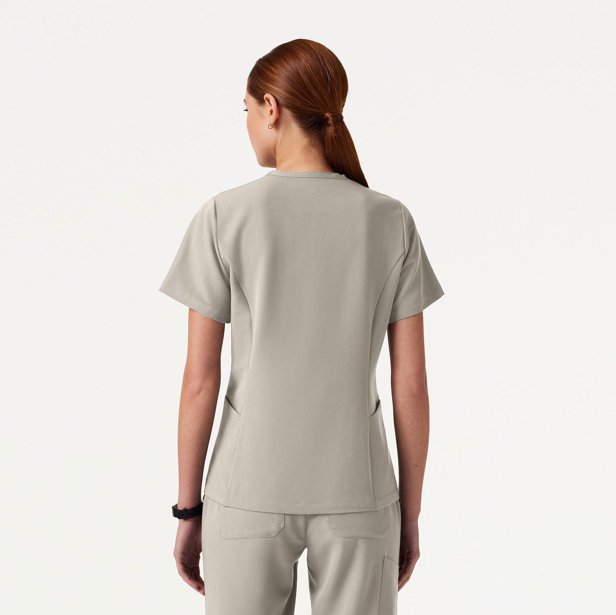 Person wearing a Fog colored scrub top and pants on a white background