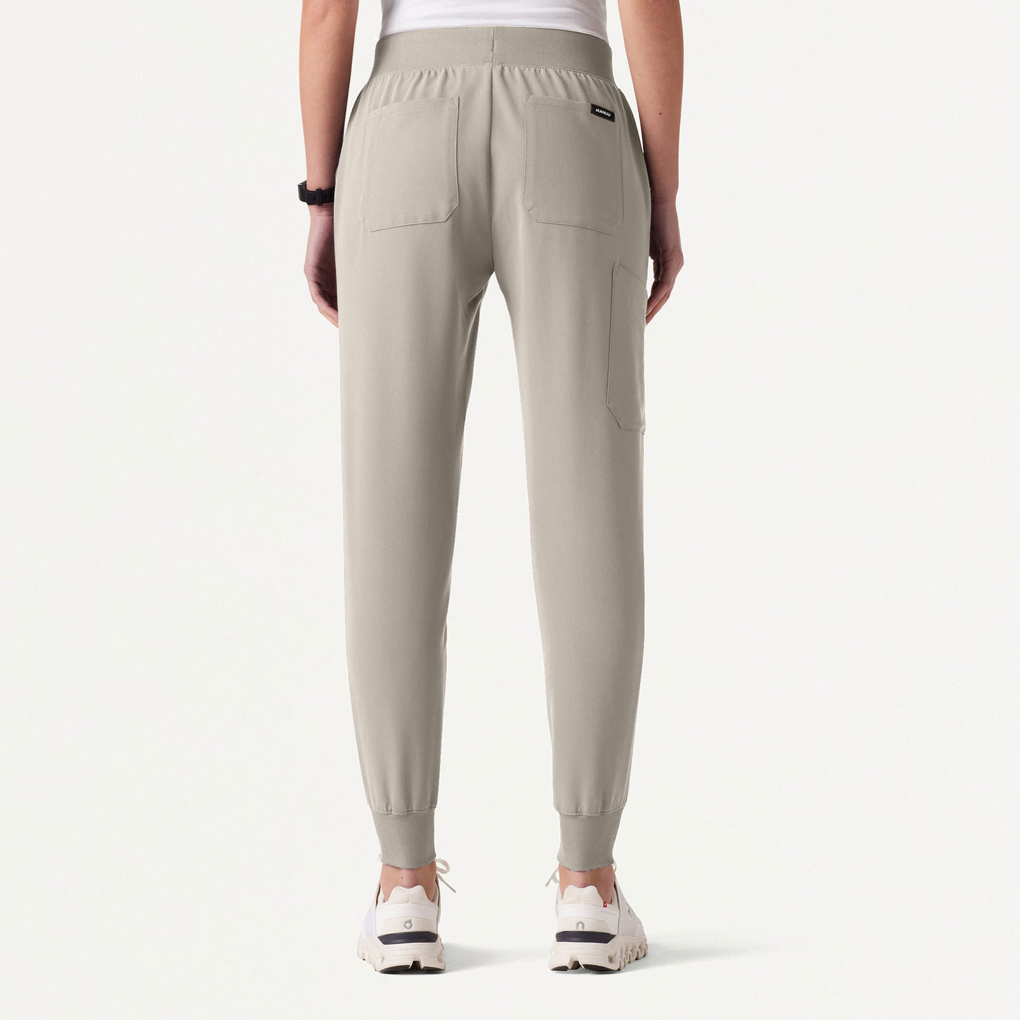 Fog colored jogger pants worn by a person on a white background