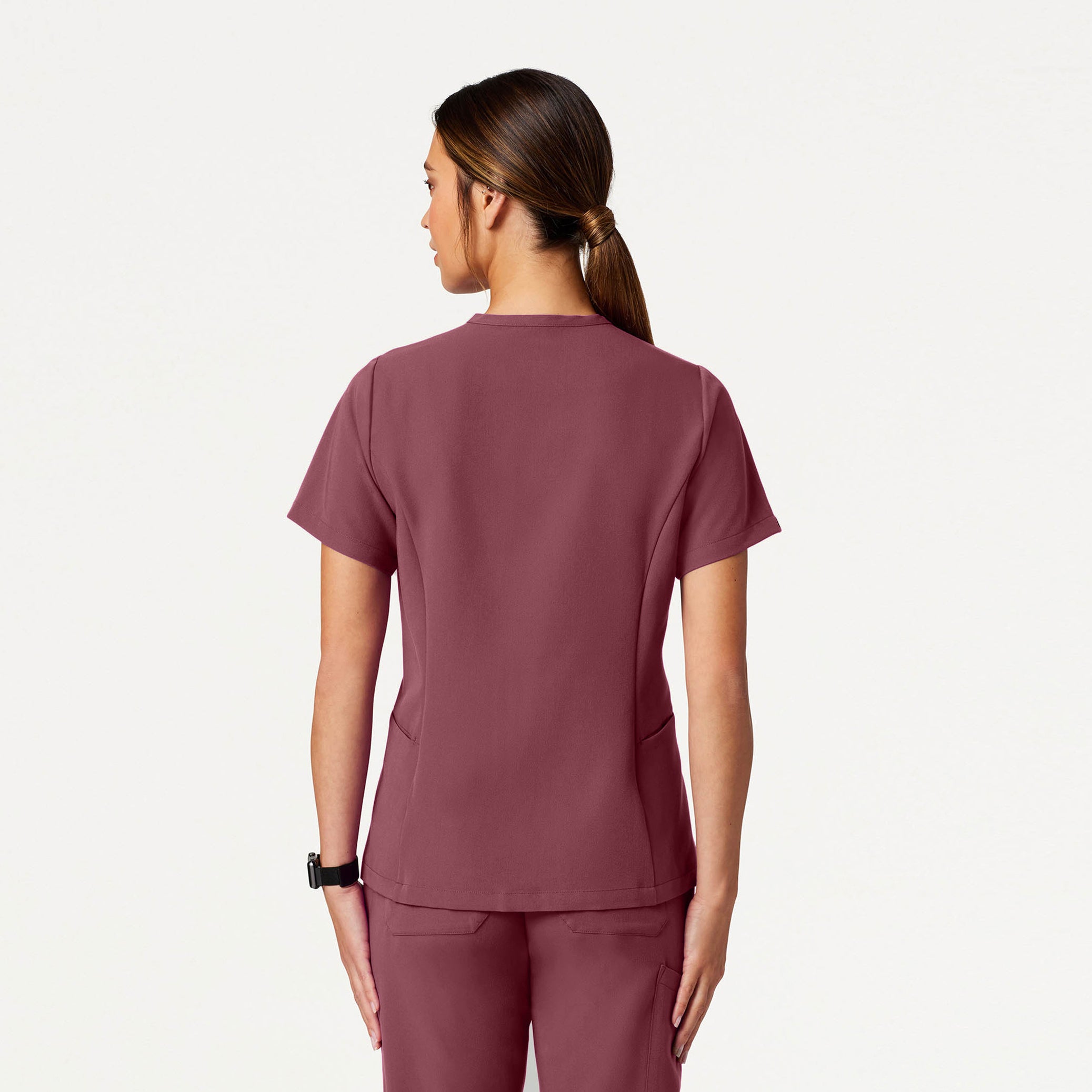 Person wearing a Rosewood scrub set on a white background