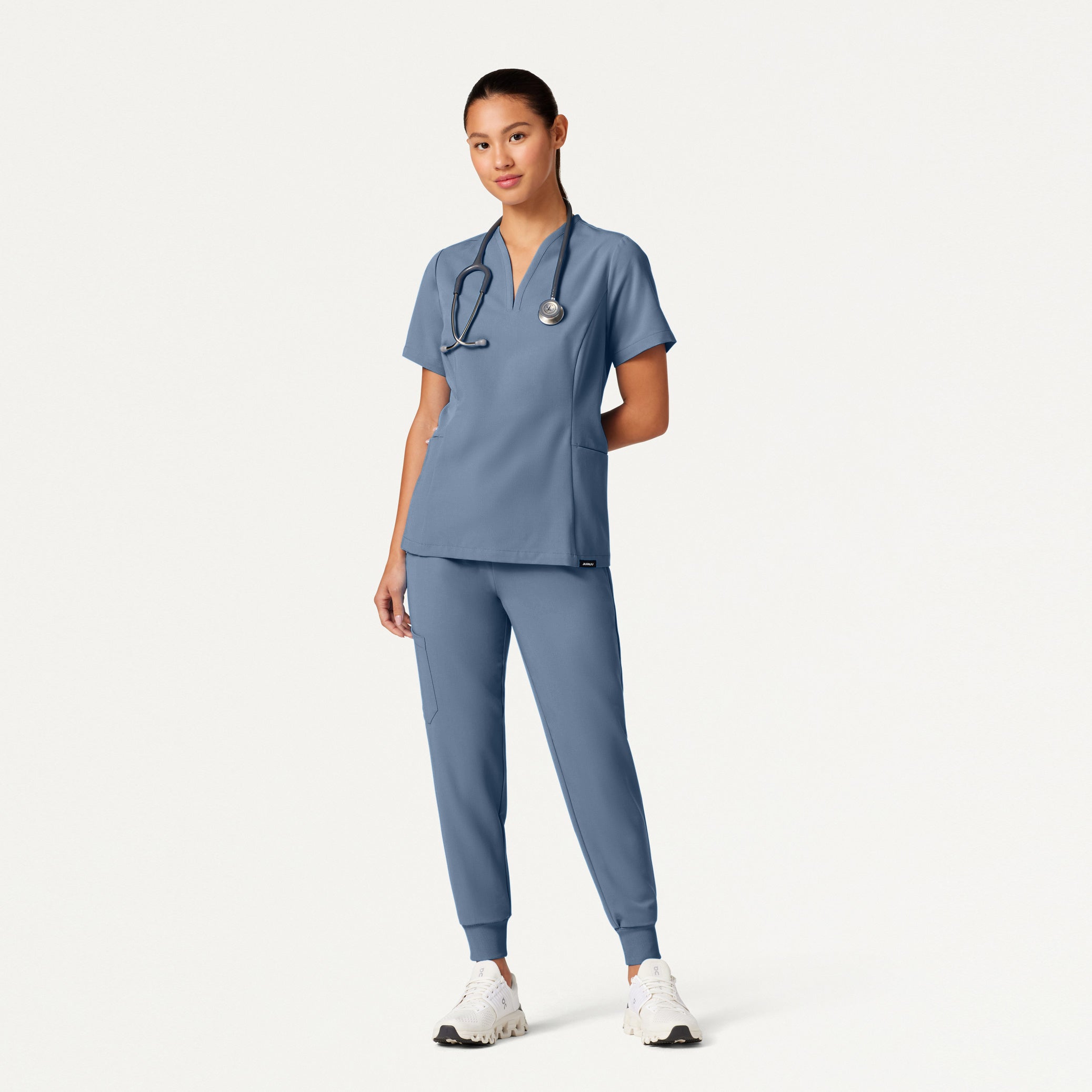 Person wearing a blue scrub set on a white background