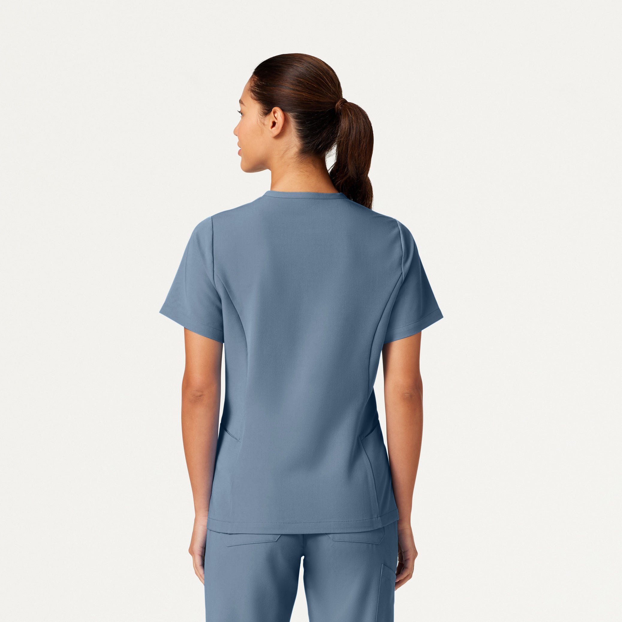 Person wearing a blue scrub set on a white background