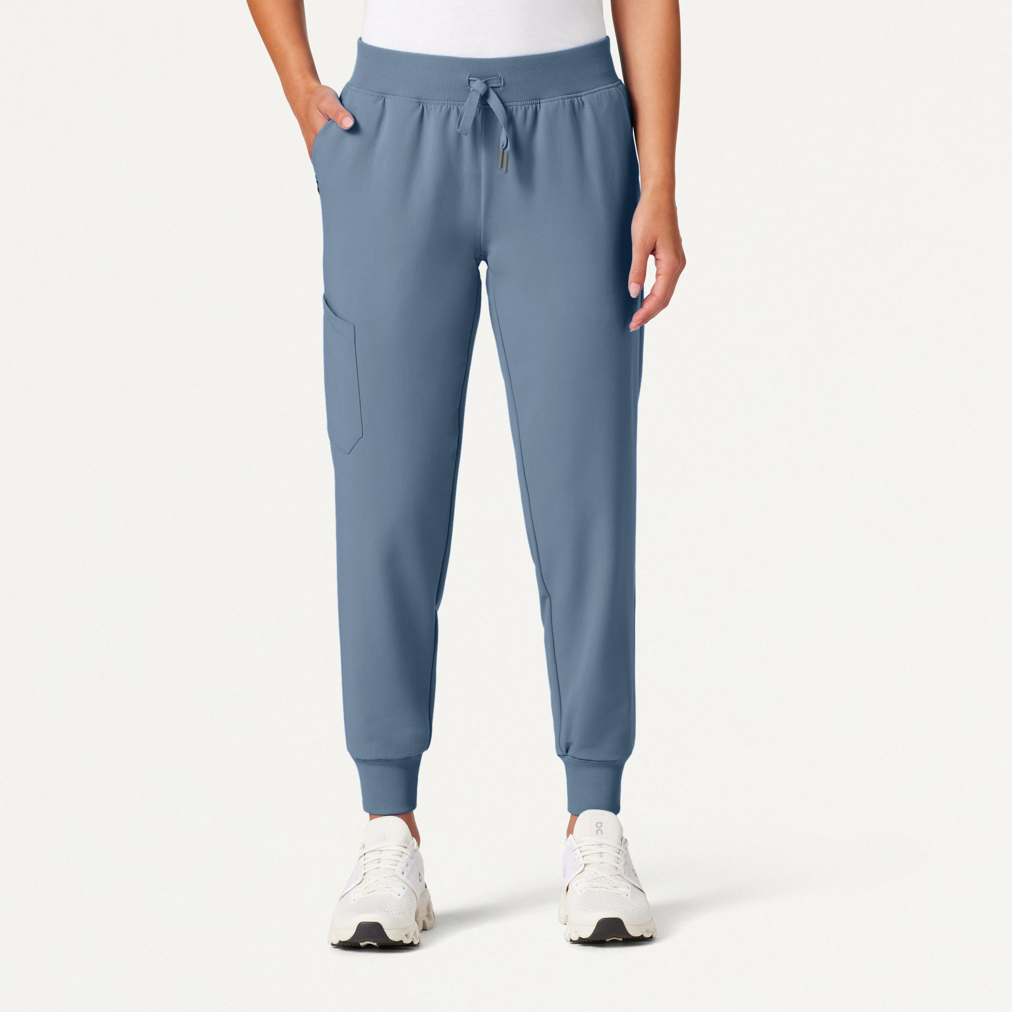 Blue jogger pants worn by a person on a white background