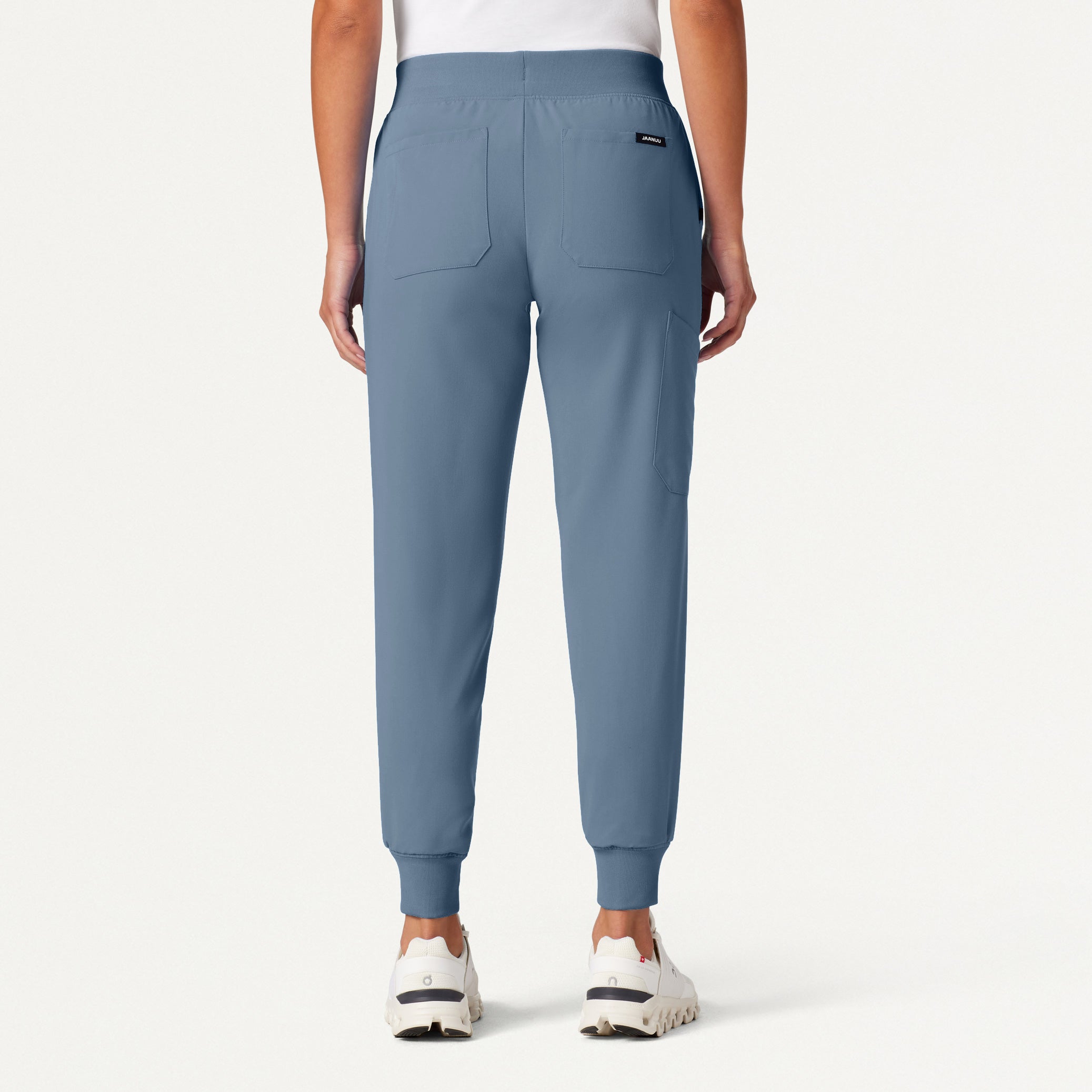 Blue jogger pants worn by a person on a white background