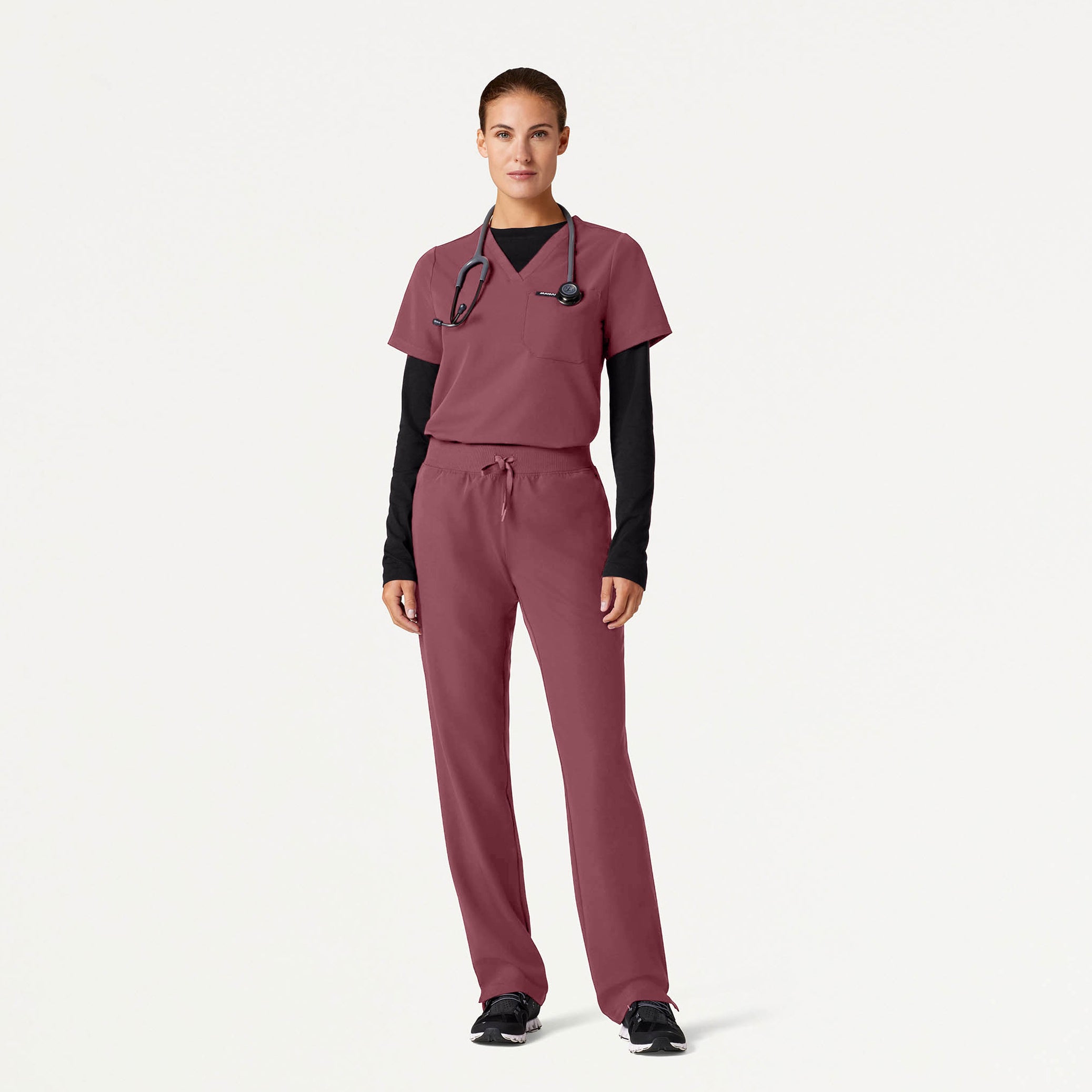 Woman wearing Rosewood scrubs with Black underscrub