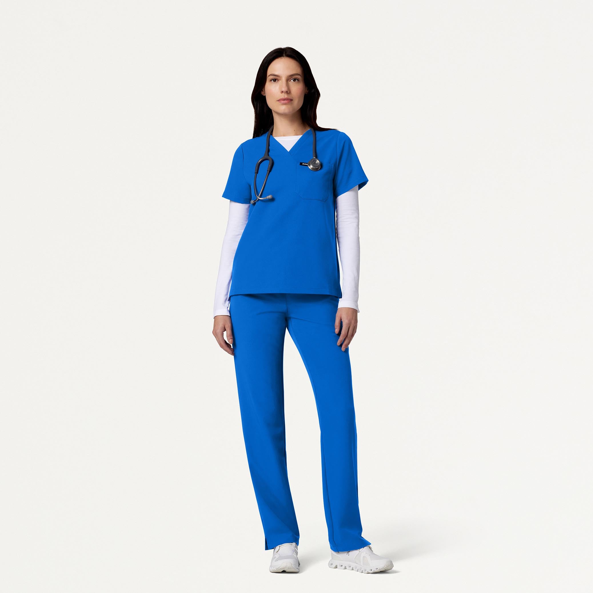 Woman wearing Royal Blue scrubs with white underscrub