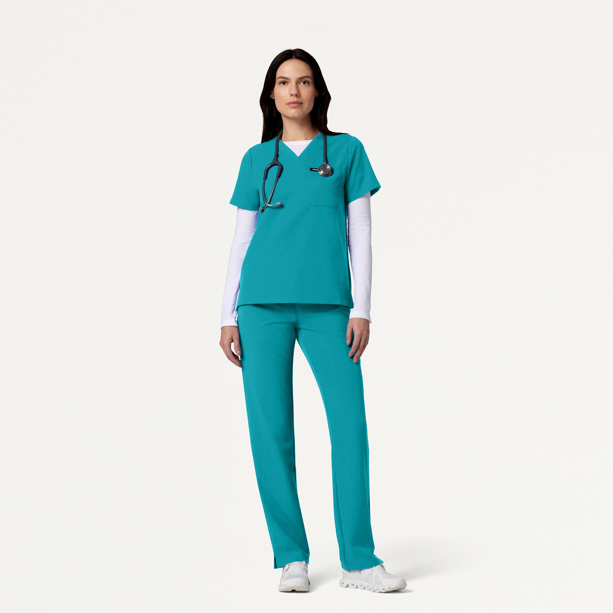 Woman wearing Teal scrubs with White underscrub