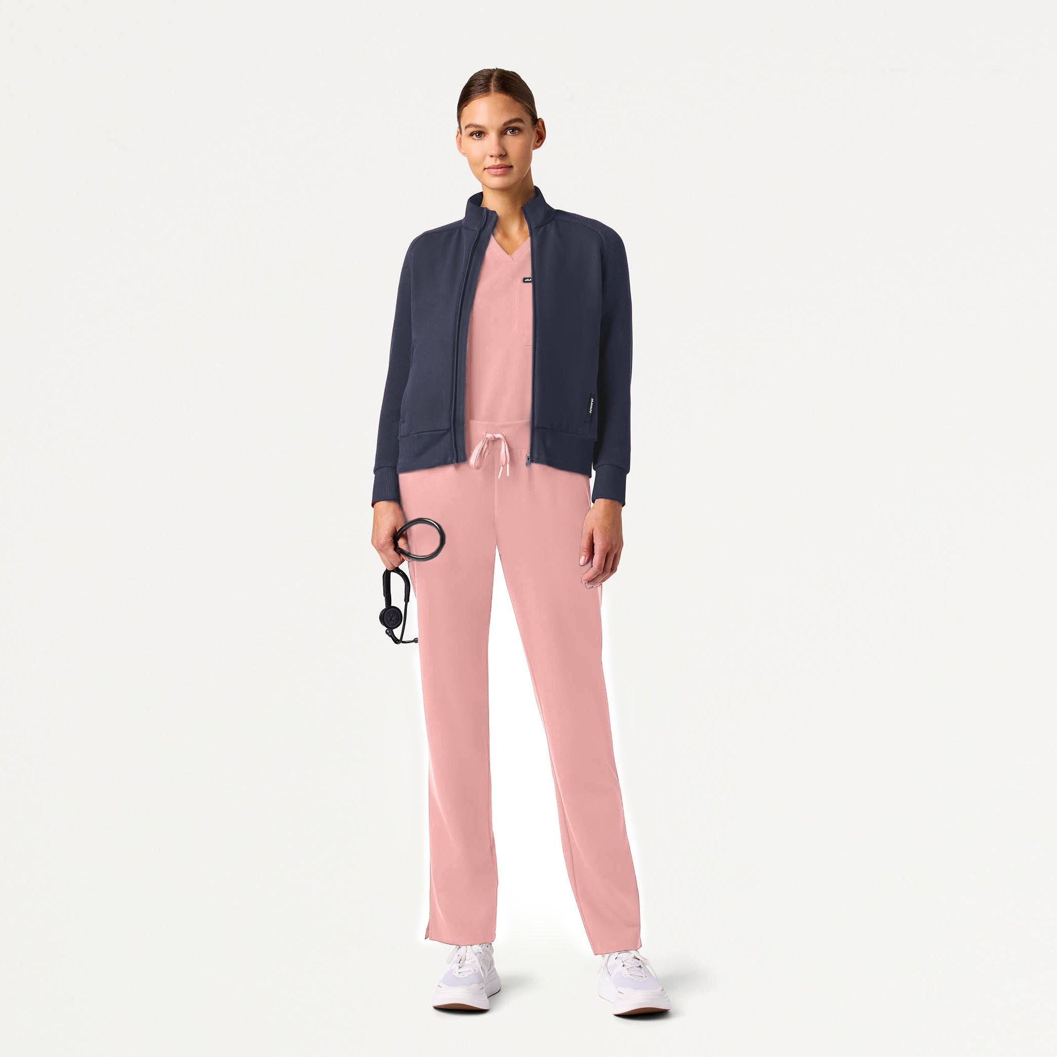 Woman wearing a jacket and pink pants on a white background