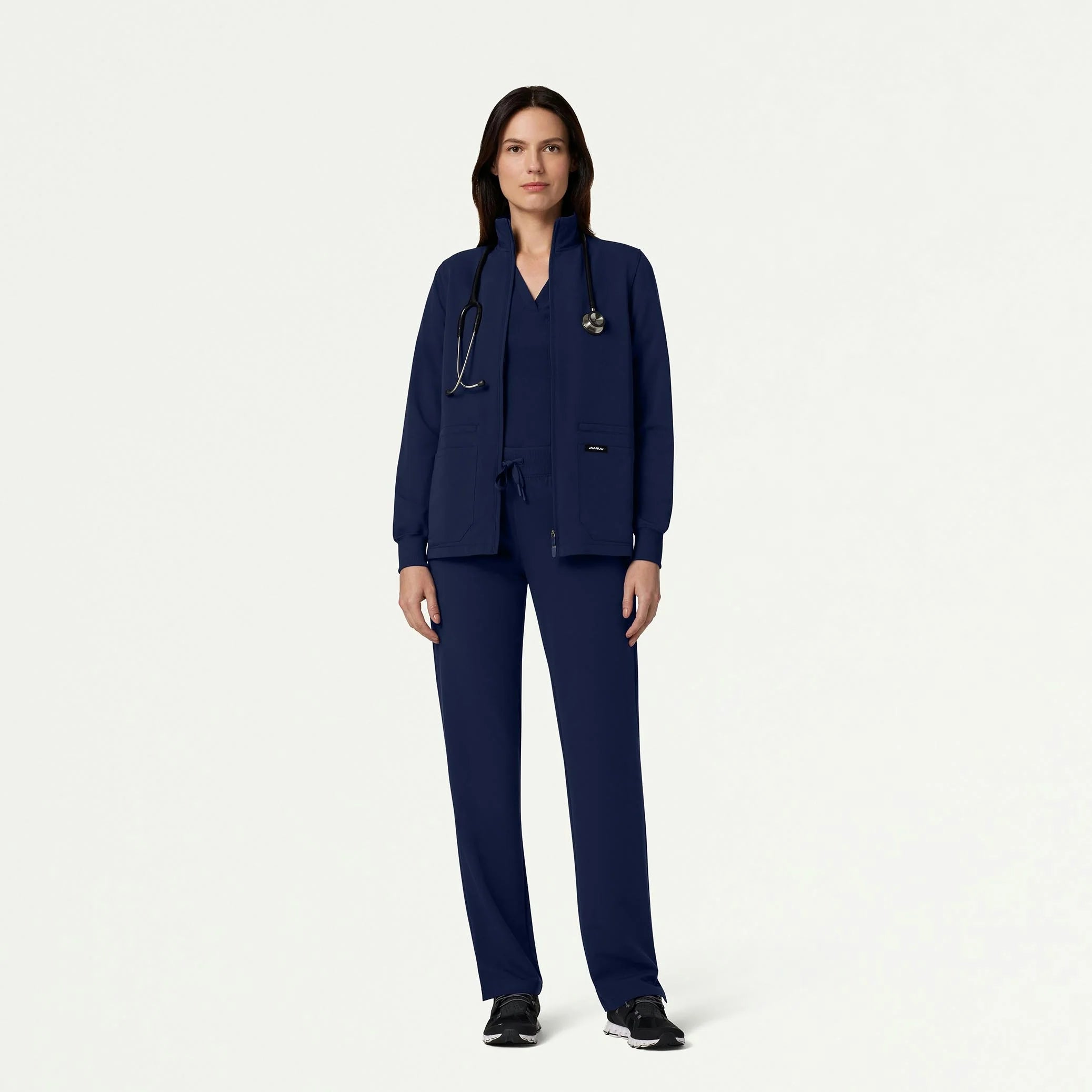 Woman wearing navy scrub set with jacket
