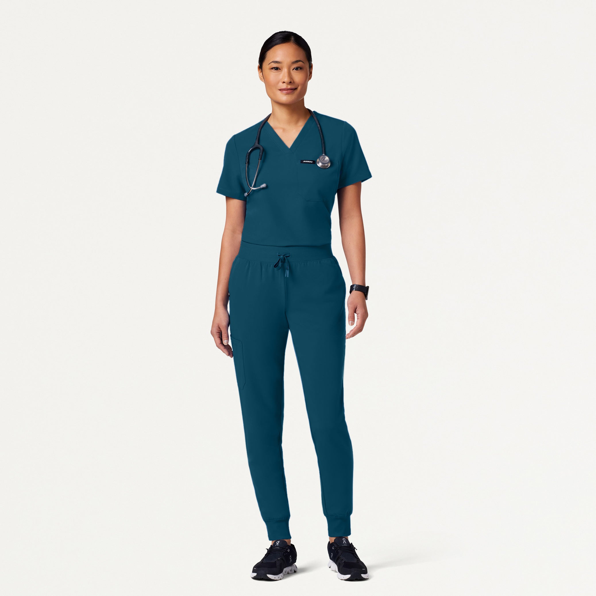 Person wearing Caribbean Blue medical scrubs on a white background